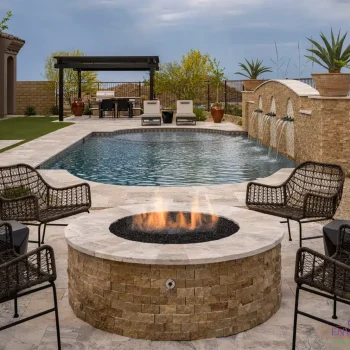 Custom backyard design with circular fire pit, slatted metal shade structure and water feature into pool.