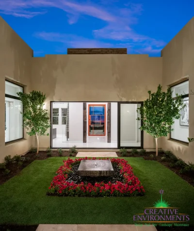 Custom courtyard design with annuals, organized planting and water feature as a focal point.