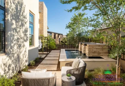 Custom backyard design with metal trellis, metal scupper water feature and natural stone paver steps.