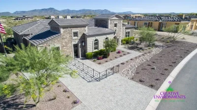 Custom front yard design with metal fencing, paver driveway and organized planting.