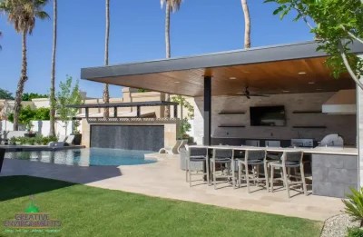 Backyard design with shade structure, outdoor kitchen and multiple dining areas.