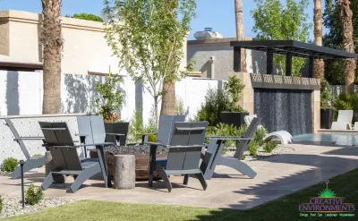 Backyard design with deco-tile wall and seating area around fire pit.