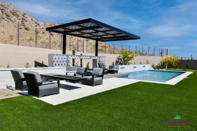 Custom backyard design with cantilevered shade structure, multiple seating areas and blue pool.