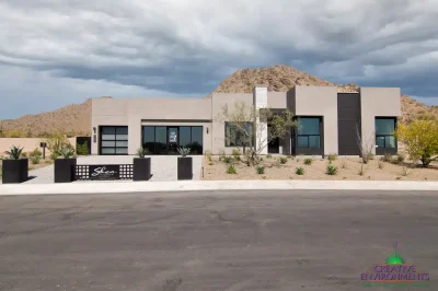 Custom front yard design with desert landscape design, metal sign and metal planters.