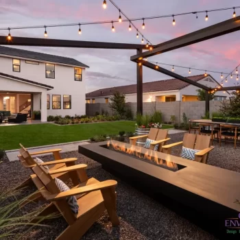 Backyard design with string lights, real grass and fire table.