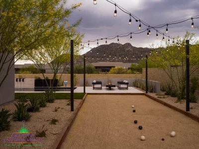 Custom backyard design with string lights, bocce ball court and organized planting.