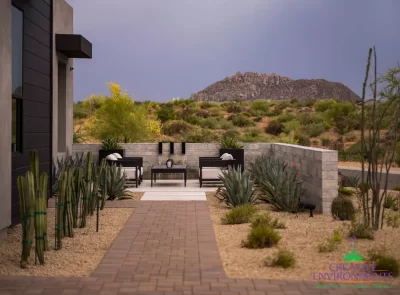Custom front yard design with privacy wall, metal scupper water feature and outdoor seating area.