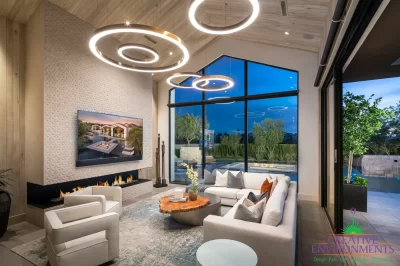 Custom indoor/outdoor living experience with up lighting, sunken fire pit into pool and trees.