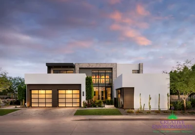 Custom front yard design with artificial turf, up lighting and cacti.