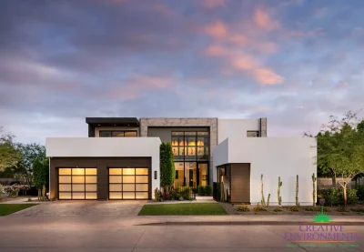Custom front yard design with artificial turf, up lighting and cacti.