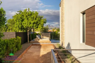 Custom side yard design with bocce ball court, water feature into pool and lounging area.