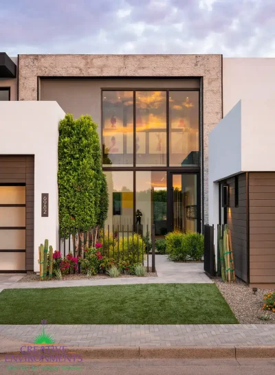 Custom front yard design artificial turf, natural stone walkway and organized planting.