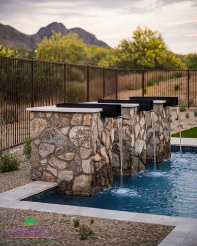 Custom metal scupper water feature into pool with desert landscape design.