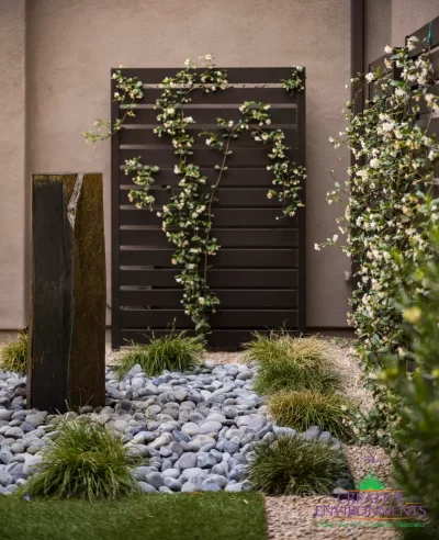 Custom backyard design with metal trellis, river rock and artificial turf.