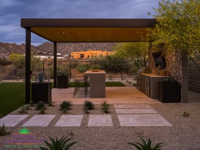 Custom backyard design with paver steps, metal shade structure and outdoor bar seating.
