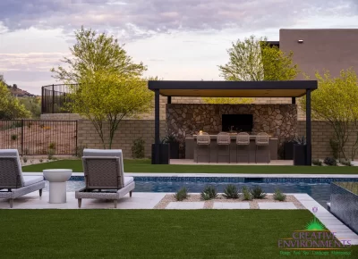 Custom backyard design with metal shade structure, outdoor dining area and pool.