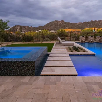 Custom backyard design blue raised spa, blue pool and water columns.