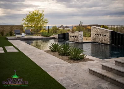 Custom backyard design with metal fencing, natural stone decking and raised outdoor entertainment area.
