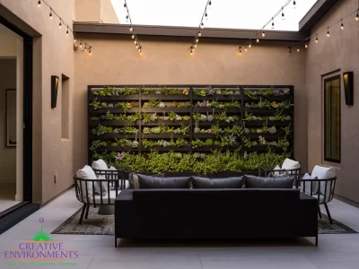 Custom courtyard design with succulent living wall, string lights and outdoor seating area.