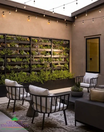 Custom open-sky courtyard design with string lights, succulent living wall and outdoor seating area.