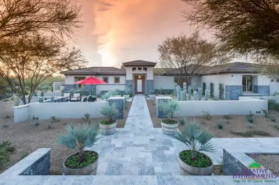 Custom front yard design with natural stone tile pathways, cacti and palm trees.