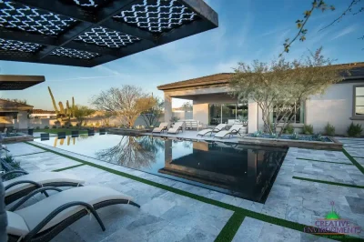 Custom backyard design with cantilevered shade structure, natural stone steps and large planters with trees and small succulents.