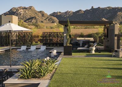 Custom backyard design with shade structure, custom metal dividers and large planters.