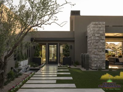 Custom backyard design with large planters, custom water feature and travertine steps.