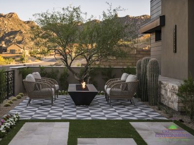 Custom front yard design with fire table, artificial grass and deco-tile flooring.