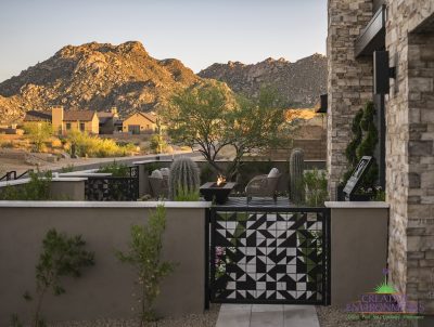 Custom front yard design with custom metal gate, topiaries and cacti.