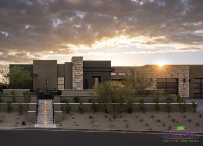 Custom front yard design with step lighting, organized planting and custom metal work.