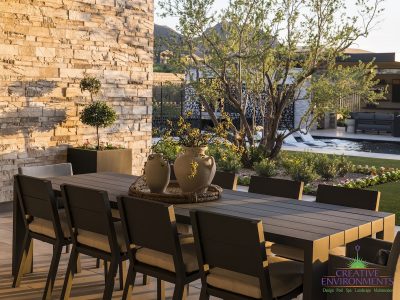 Custom backyard design with outdoor dining area, large planters and custom metal dividers.