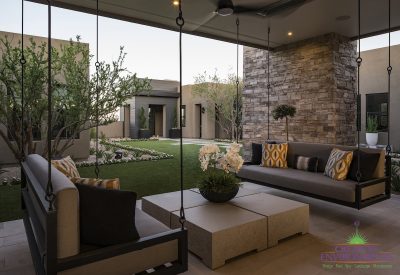 Custom backyard design with hanging couches, artificial grass and succulents.