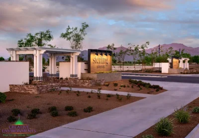 Custom community entryway with custom entryway sign, white shade structure and organized planting.