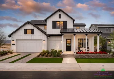 Custom front yard design with organized planting, mixed material driveway and annuals.