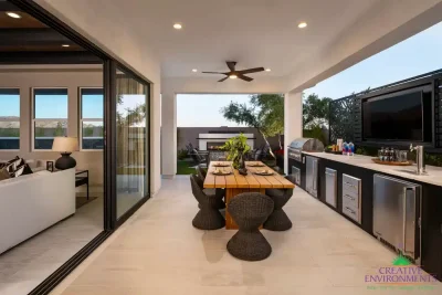 Custom backyard design with recessed lighting, metal statement piece and outdoor kitchen with dining area.