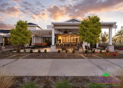 Custom community entrance with string lights, white shade structure and multiple seating areas.