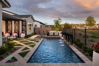 Custom backyard design with artificial turf pattern, water scuppers into pool with natural stone decking.