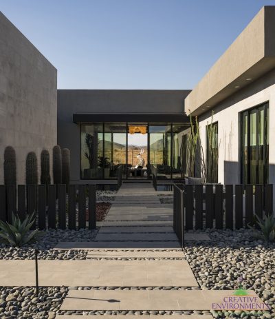 Custom front yard design with metal statement piece, metal fencing and cacti.