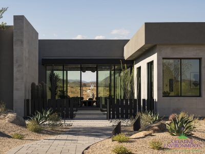 Custom front yard design with metal statement piece, succulents and metal fencing.