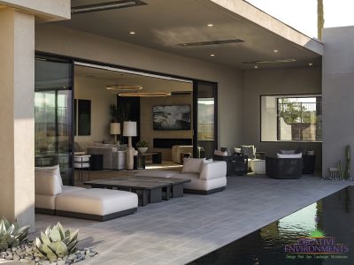 Custom backyard design with zero-edge pool, multiple seating areas and covered patio.