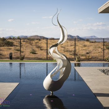 Custom backyard design with zero-edge pool, metal statue in pool and custom metal work.