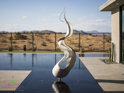 Custom backyard design with zero-edge pool, metal statue in pool and custom metal work.