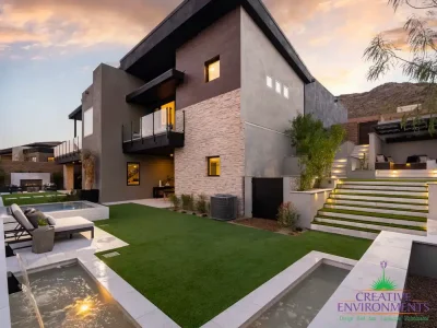 Custom backyard design with water features, cantilevered shade structure and fireplace.