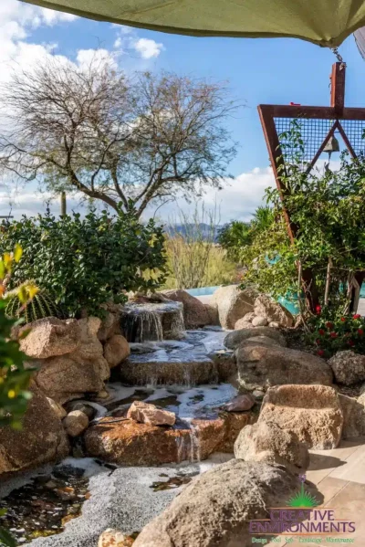 Backyard design with natural stone waterfall and triangular accents