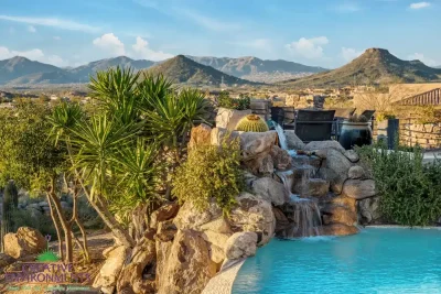 Backyard design with natural stone waterfall into pool