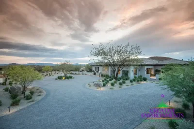 Custom front yard design with brick paver roundabout and desert planting.