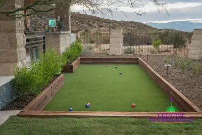 Custom backyard design with bocce ball court, artificial turf and metal fencing.