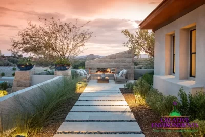 Custom backyard design with angled fireplace, natural stone steps and desert plants with up lighting.