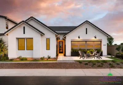 Custom front yard design with seating area and large potted plants.